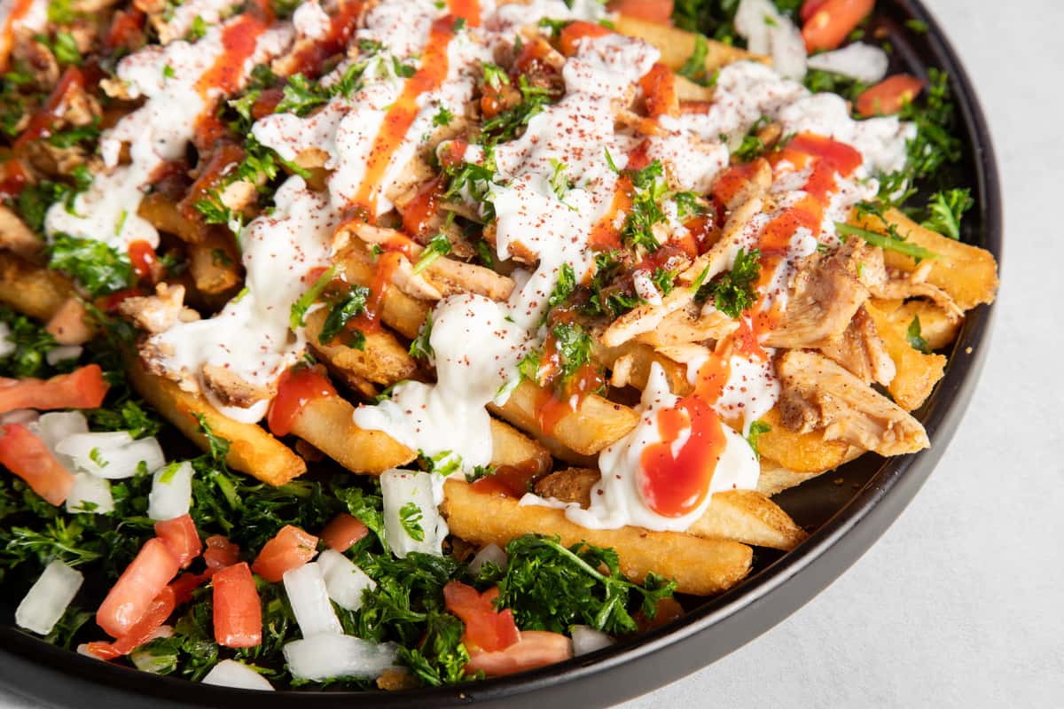 Close up of Chicken Shawarma Fries on a black plate