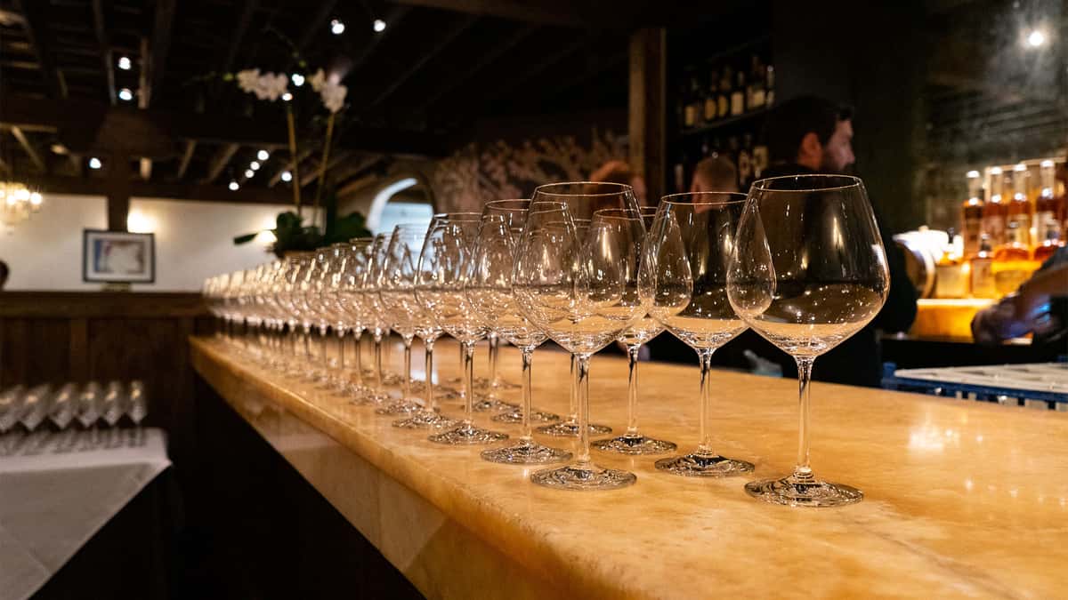 long row of wine glasses on bar