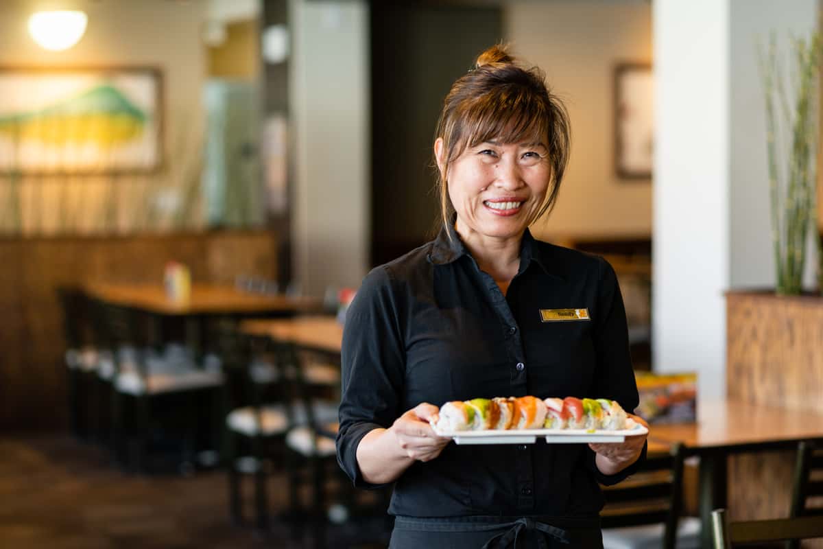 Gyotaku staff membering holding a plate of sushi