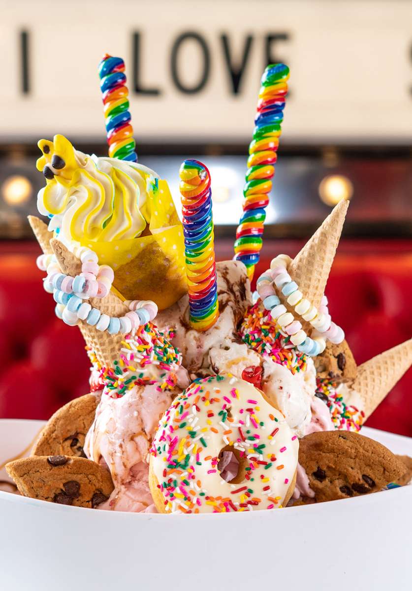 Sundae topped with lollipops, candy, donuts and cookies