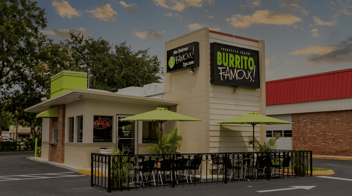 Exterior of Burrito Famous restaurant with outdoor patio seating under lime green umbrellas.