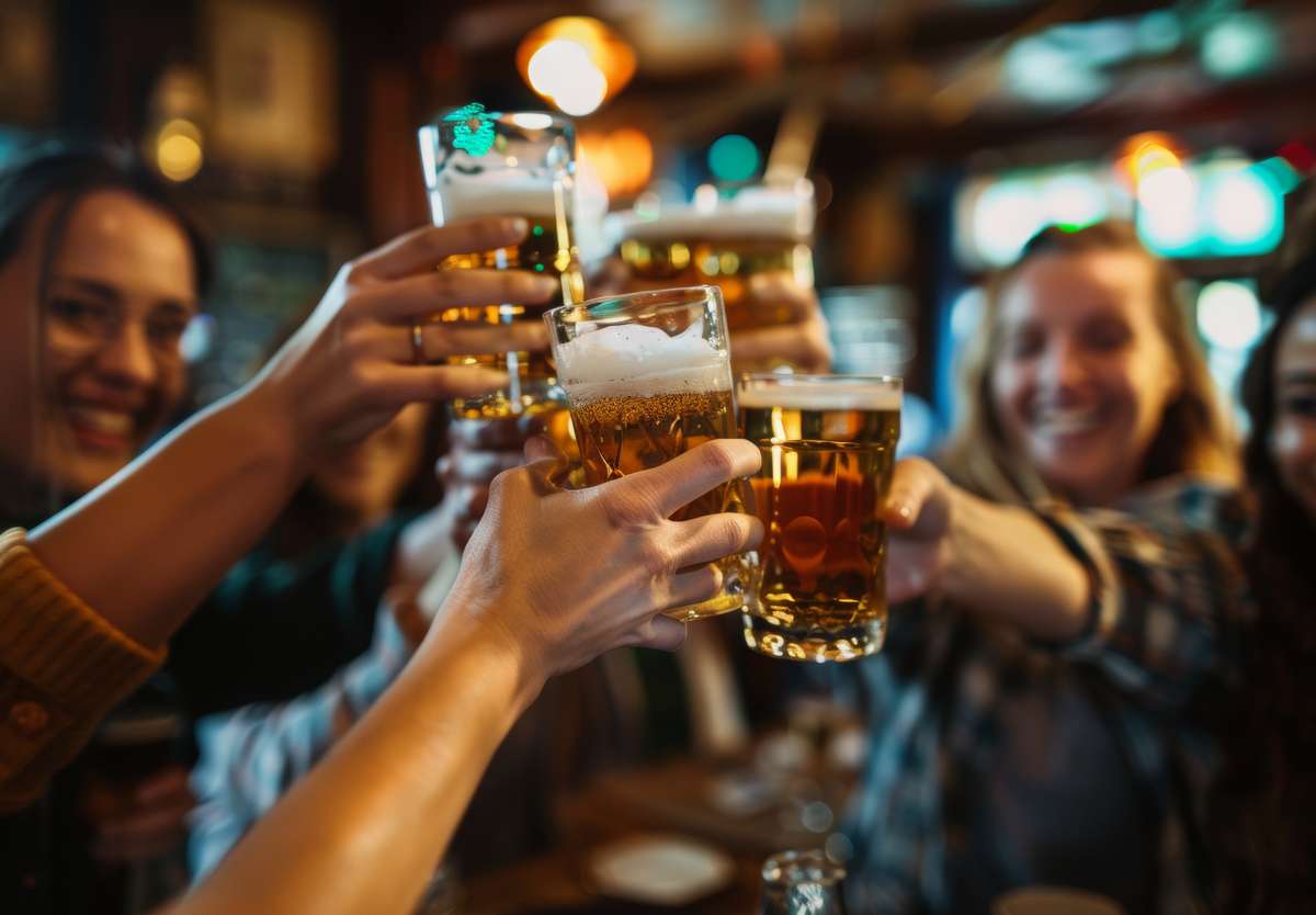 Group of friends smiling and raising beer mugs together in a toast