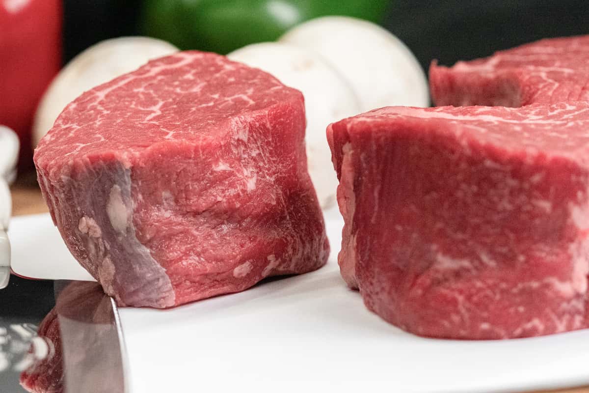 multiple raw beef filet cuts grouped together showing marbling and premium quality