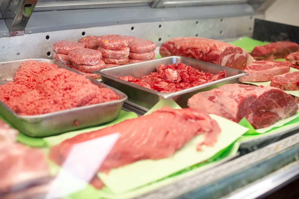 butcher shop display case with fresh cuts of beef and ground meat neatly arranged