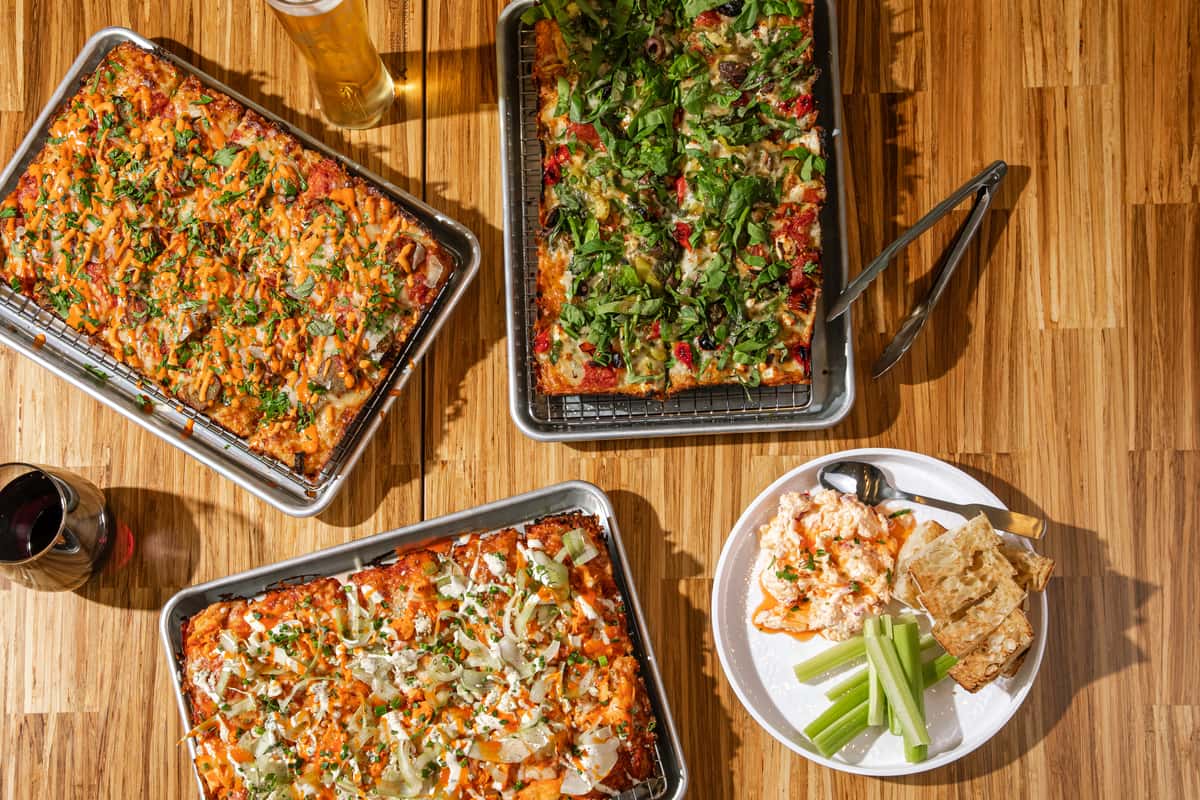 Three Electric Dough pan pizzas on butcher block in San Marco, Jacksonville.