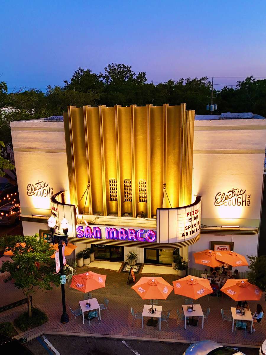 The restored 1938 San Marco Theatre at dusk with its neon marquee lit, home of Electric Dough Pizza Co. and its Detroit-style pan pizza in Jacksonville, Florida.