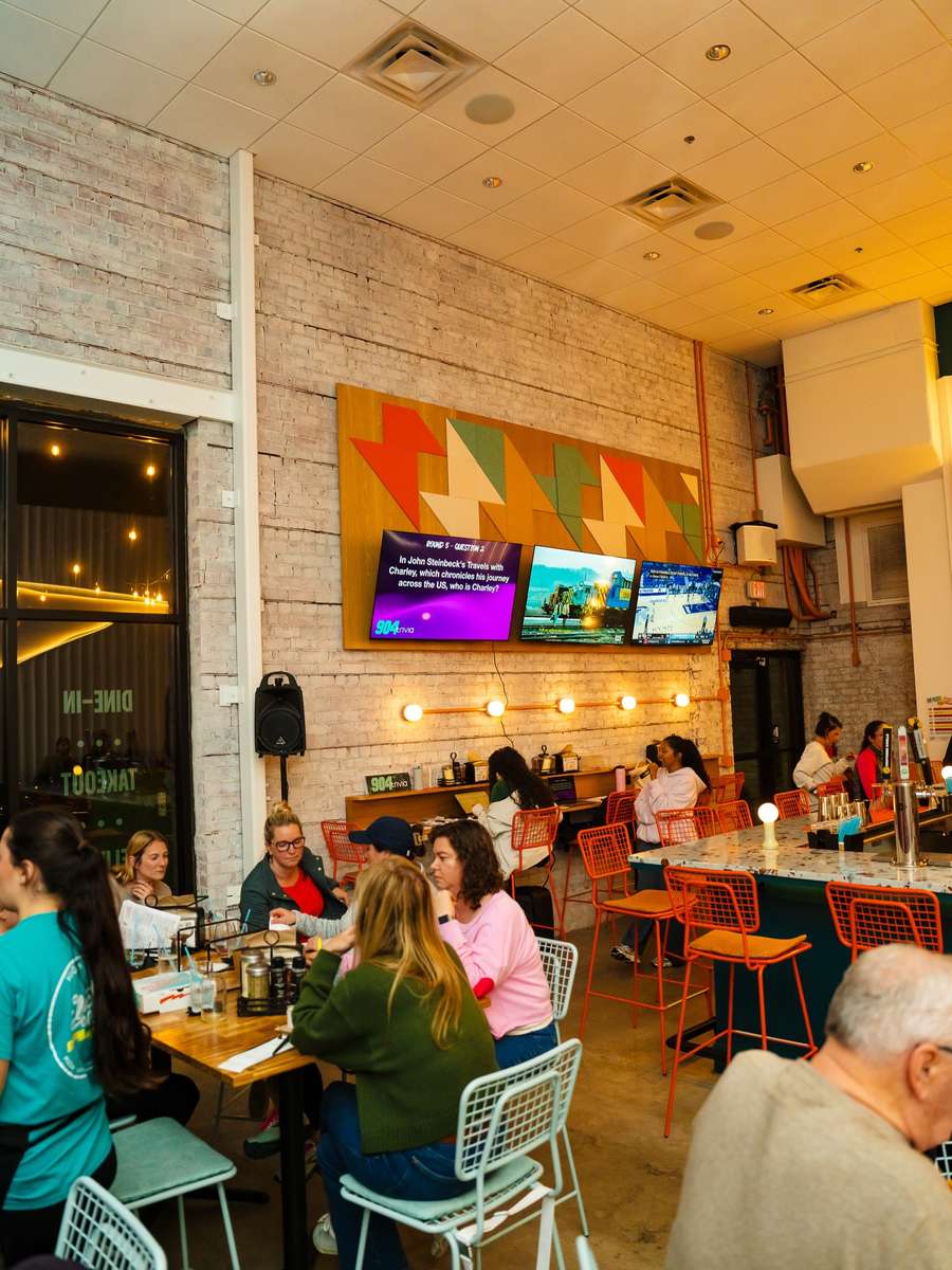 A busy evening in the Electric Dough Pizza Co. dining room, guests at every table.