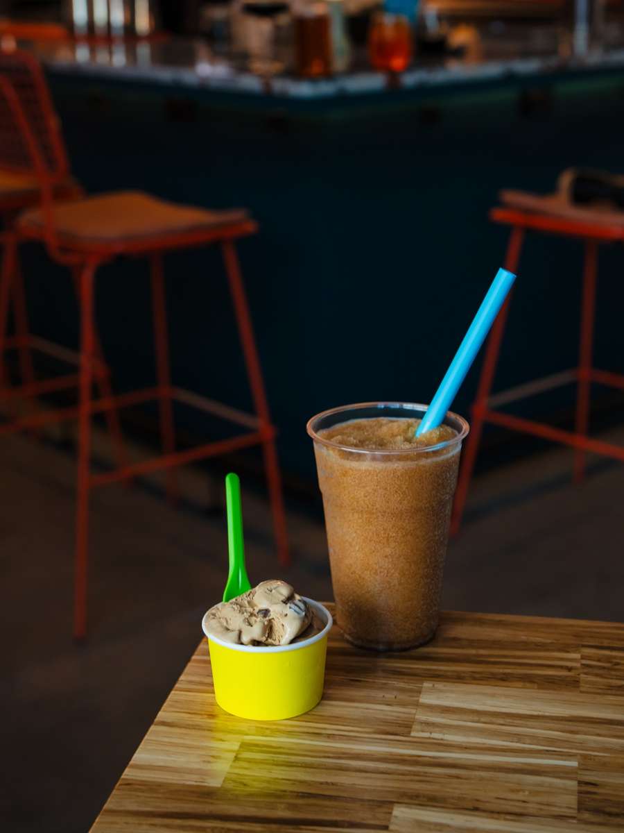 A cup of Italian gelato and a frozen Tractor craft slushee on the table at Electric Dough Pizza Co. in San Marco, Jacksonville.