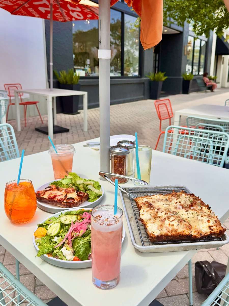 The lunch special, a slice and a salad with a drink on the patio.