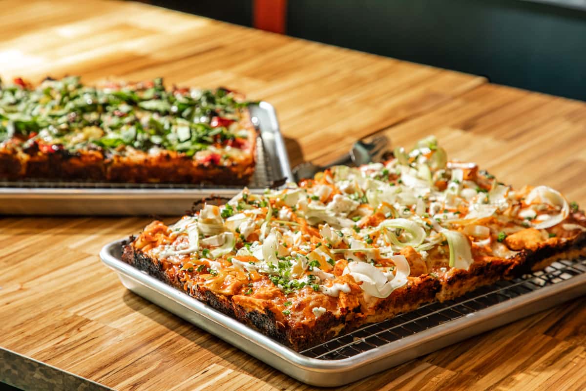 Detroit-style pan pizza in Jacksonville: the caramelized, cheese-to-the-rim edge of an Electric Dough pie.