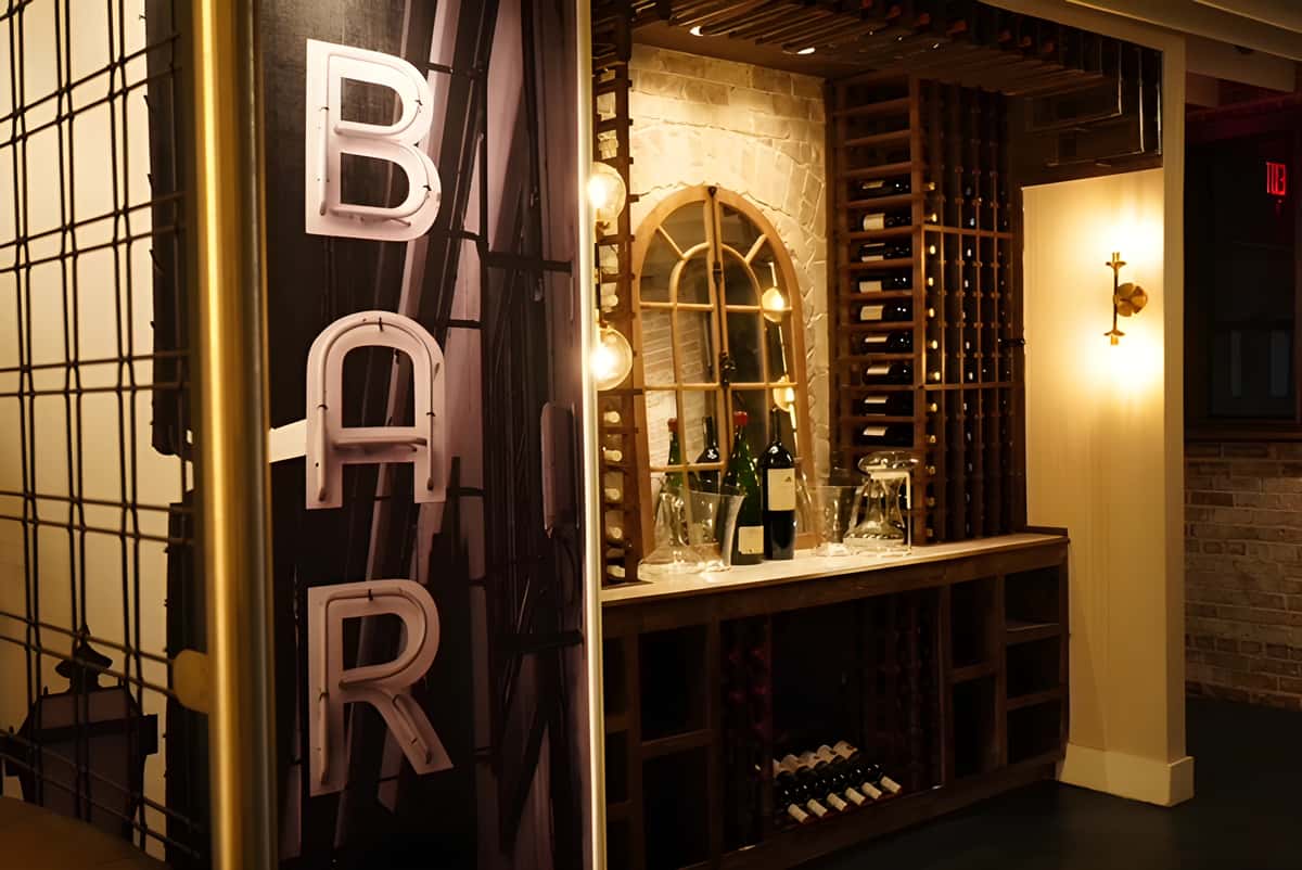 Bar entrance with vertical "BAR" sign and shelves displaying bottles.