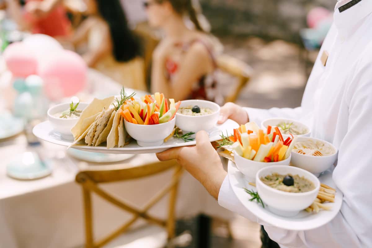 Waiter carrying dishes to guests