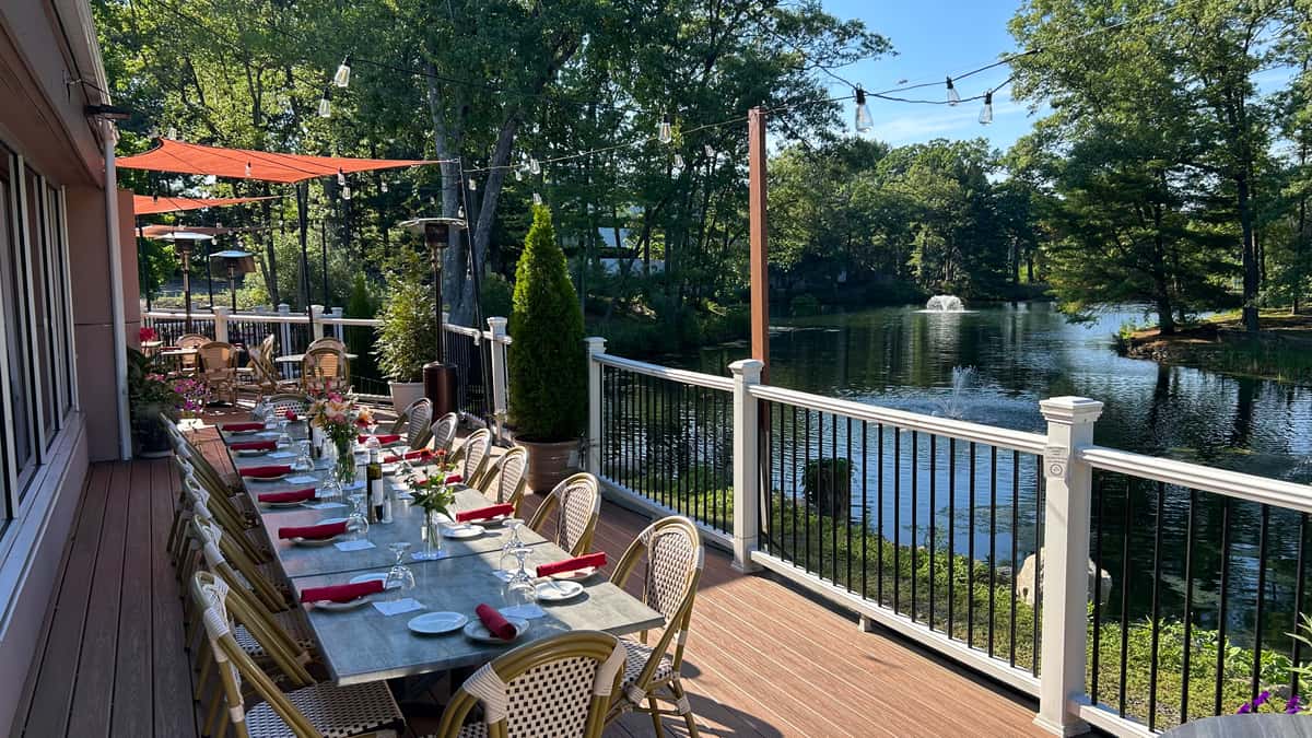Outdoor waterfront dining at La Notte Waterside Grille in Windsor, Connecticut, with tables overlooking the water.