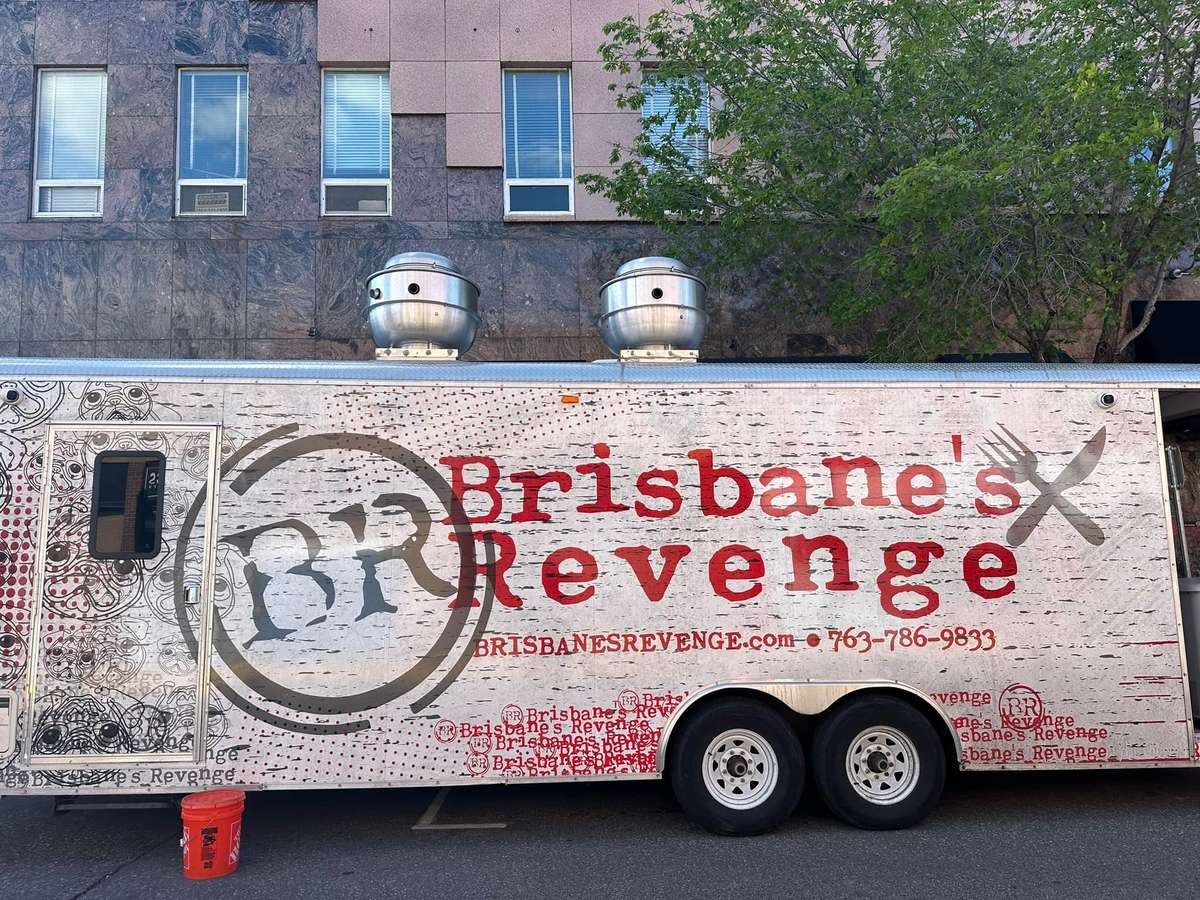 Brisbane's Revenge food truck parked on a city street with bold red lettering and pug face graphics on a weathered white background.