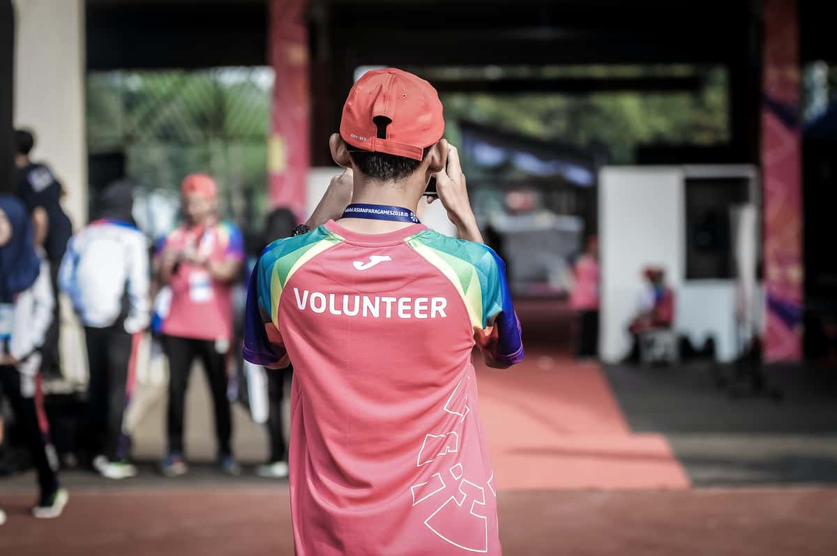 Young man wearing a shirt that says Volunteer