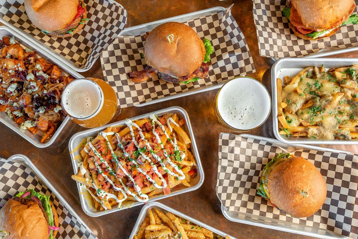 flatlay view of burgers and fries and beers