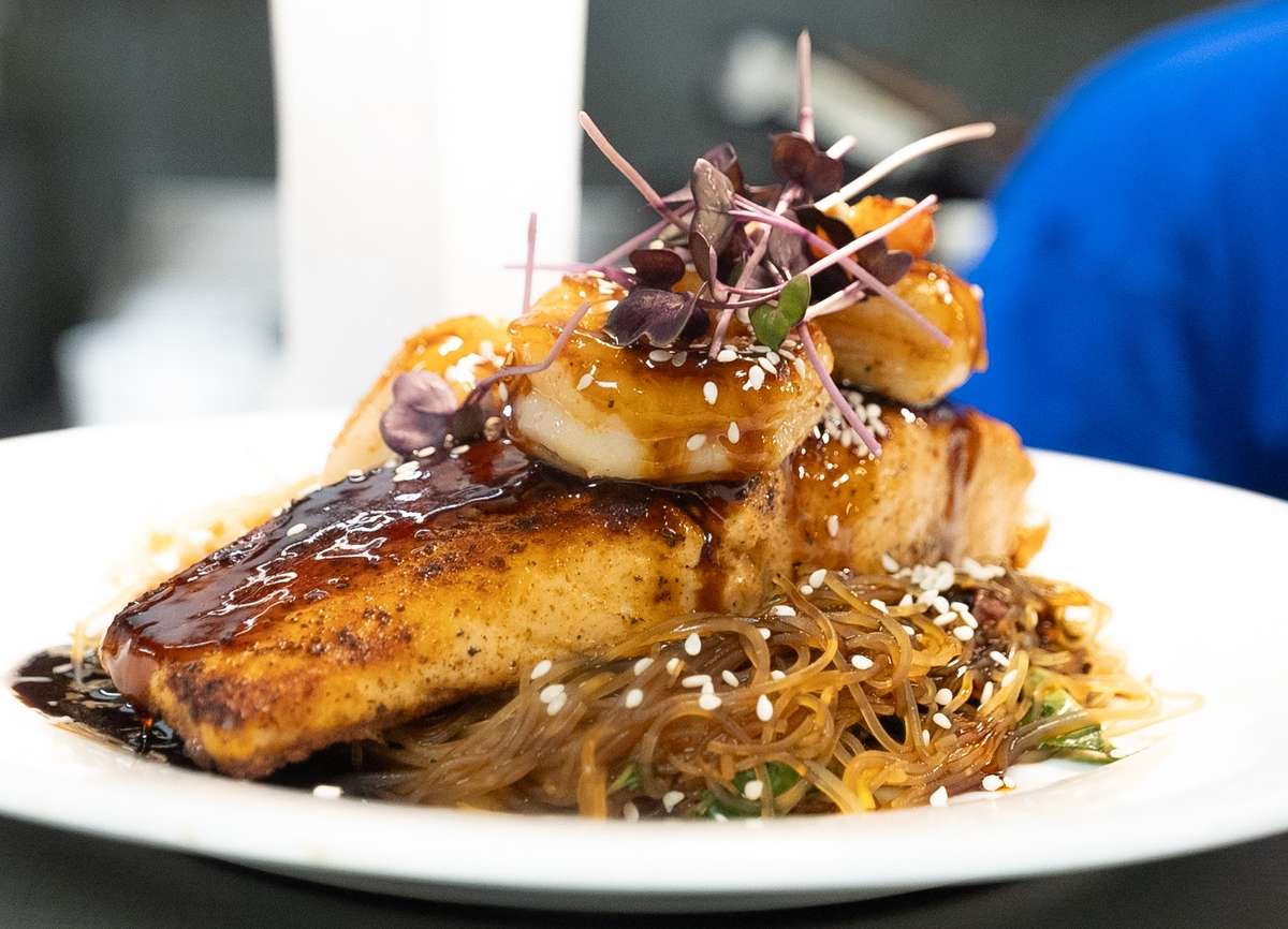 Honey soy balsamic glazed atlantic salmon jumbo shrimp, rice noodles, shaved broccoli, kohlrabi, shredded brussels, kale, radicchio and carrots Japanese plum soy glaze