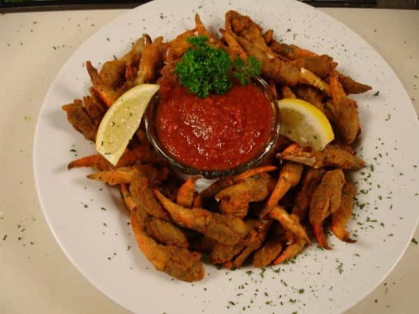 fried crab claws with dipping sauce and lemon wedges