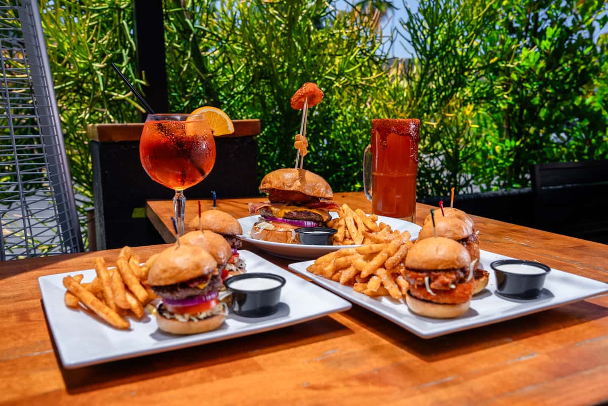 wide angle photo of burgers and sliders + drinks
