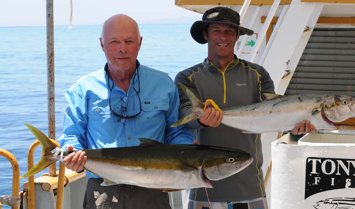 Two persons holding a fish