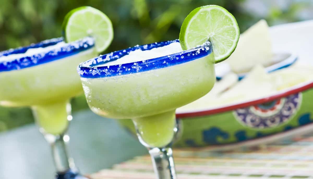 Margaritas in glasses with a lime and salted rim
