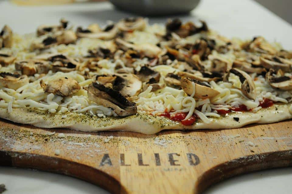 whole pizza on a wood board with a handle