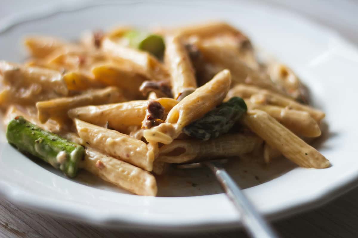Creamy penne pasta with asparagus and sun-dried tomatoes