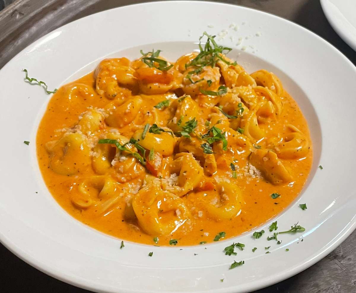 Cheese tortellini pasta in creamy tomato sauce, garnished with parsley