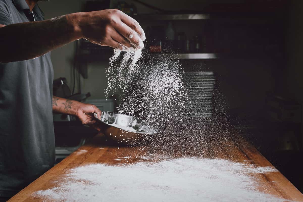 Dusting a counter with flour to prepare handmade dough