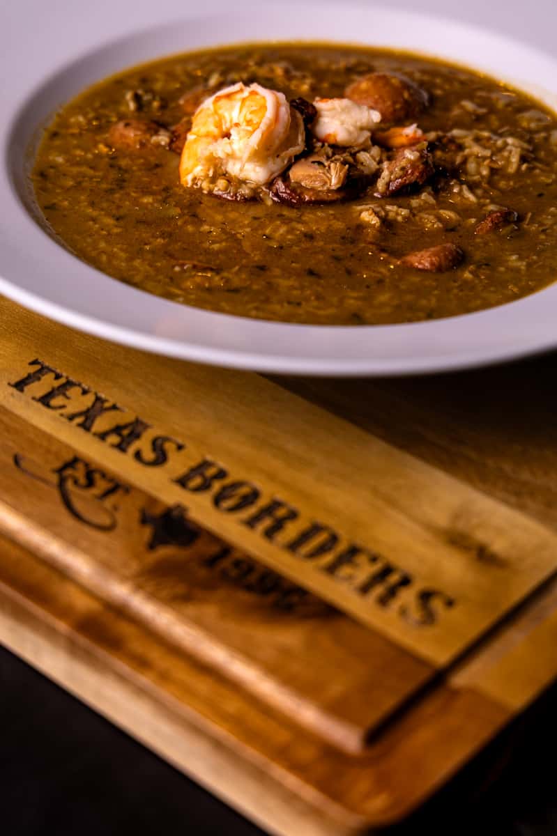 A hearty bowl of seafood gumbo with shrimp, sausage, and rice, served at Texas Borders Bar & Grill