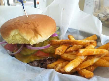 cheeseburger with pickles, onions, tomato and a side of french fries
