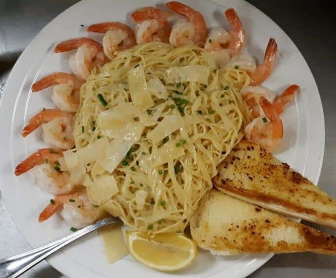 shrimp over linguine alfredo with shaved parmesan and garlic bread
