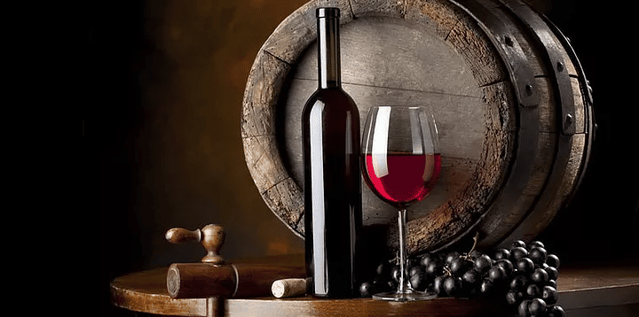 red wine in front of oak barrel
