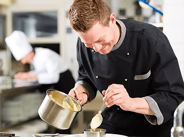 chef pouring sauce on meal