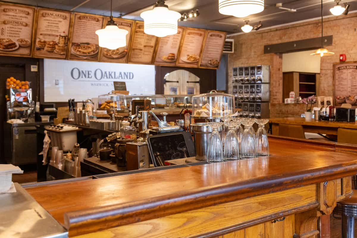 Warm diner interior with wooden bar, coffee station, and classic American breakfast counter at One Oakland