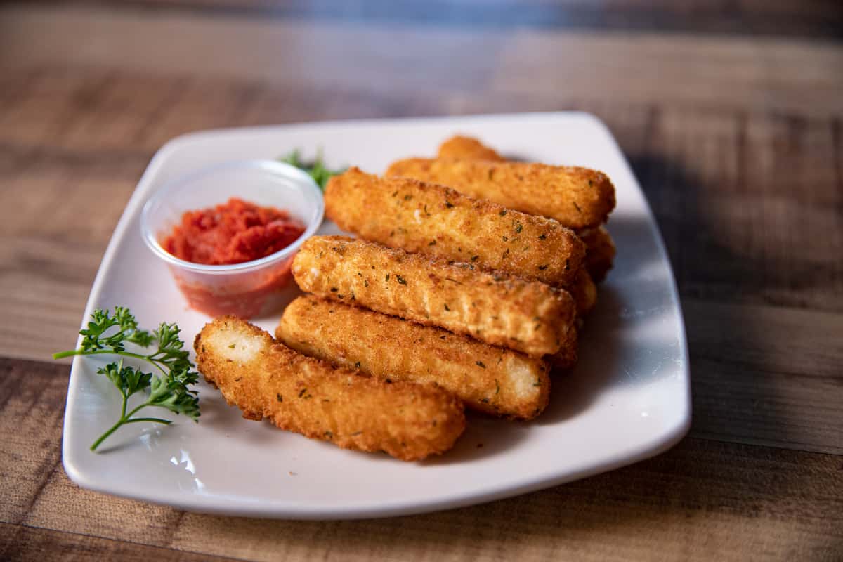 cheese sticks with a side of marinara sauce on a white plate
