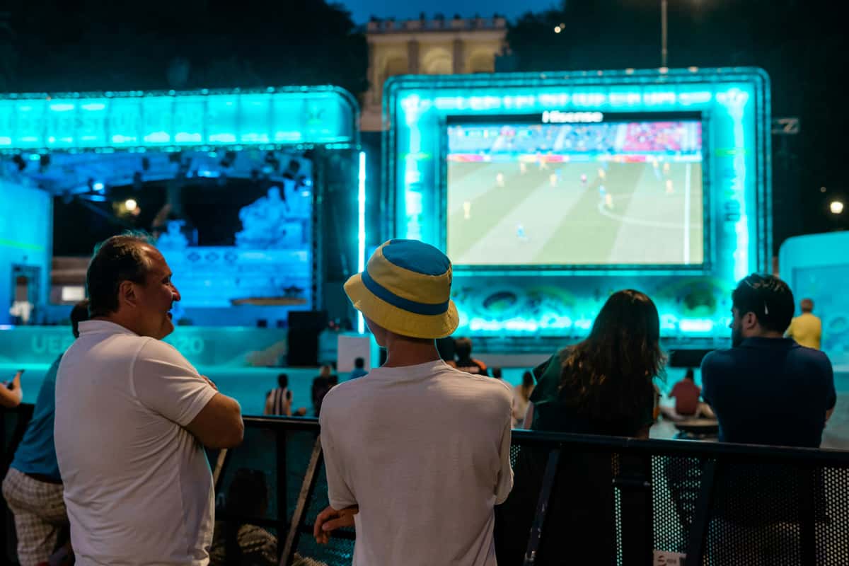 Soccer fans watching a soccer match on tv screens inside a restaurant