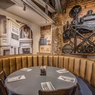 corner table with historic murals and the old film projector from the old theater behind it