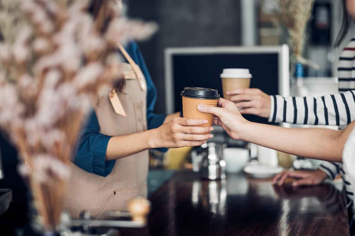 coffee barista handing over coffee 