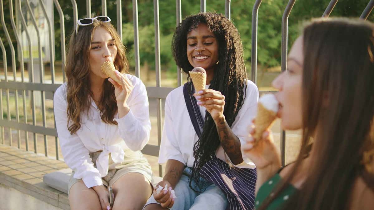 three women holding and eating ice creams