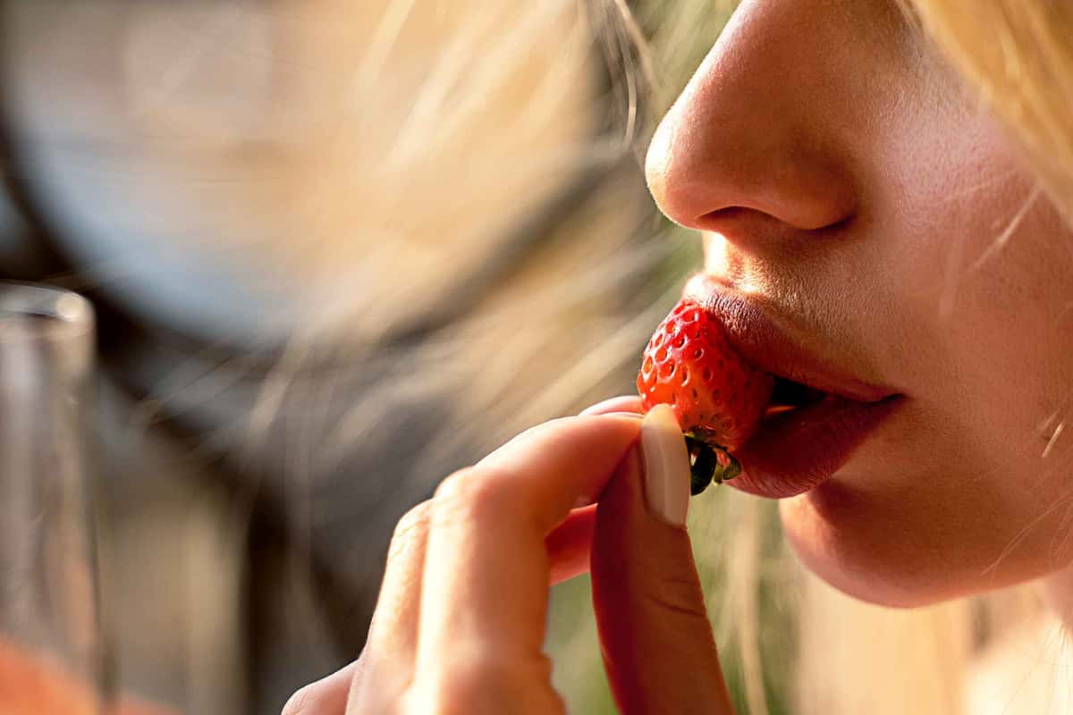 person eating a strawberry