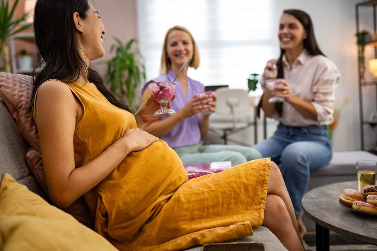 pregnant woman with two women holding ice creams