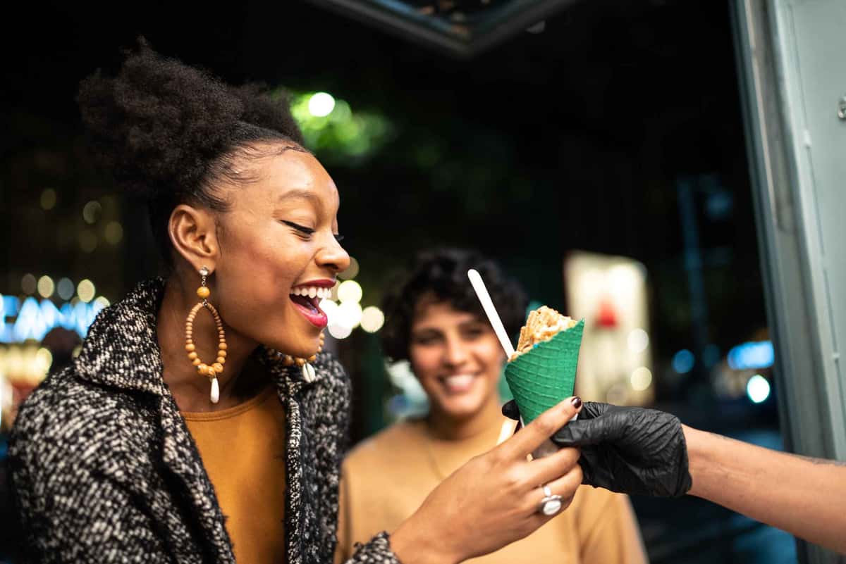 two people holding an ice cream at night