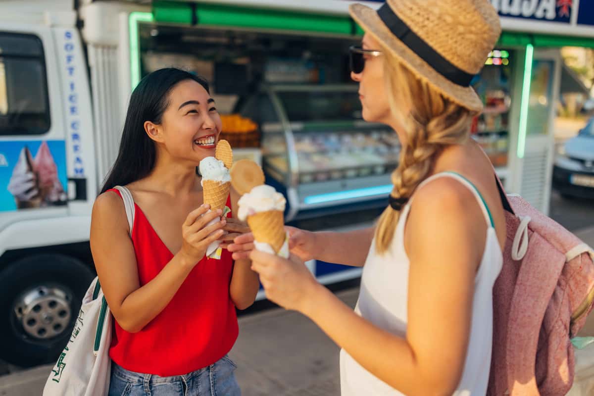 two girls with ice creams infront of a food truck