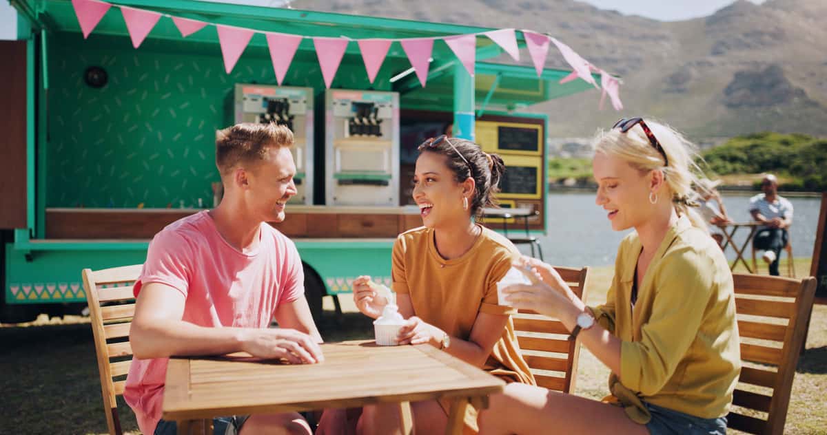 a group of people eating ice cream in front of a food truck
