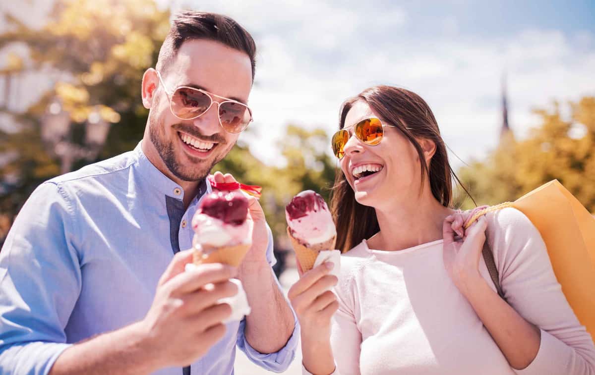 a couple wearing sun glasses holding ice creams