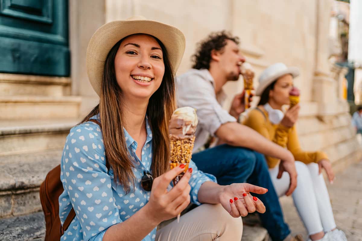 three people sitting down with an ice cream