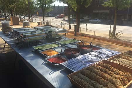 Outdoor catering table with salad bar and cookies, sternos.