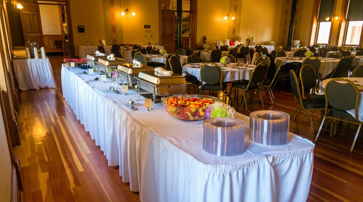 Elegant catering buffet line with chafing dishes set up for an event by A Taste of Country Catering