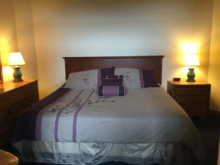 Bedroom with king-sized bed, dresser and end table with lamps